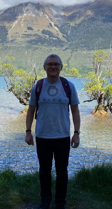 Richard stood by a lake in his Tricky Cider t-shirt